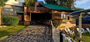a house with a balcony and a patio at Cabañas Postal de la Villa in Villa Carlos Paz