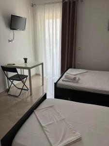 a room with two beds and a table and a chair at Meta apartment in Ksamil
