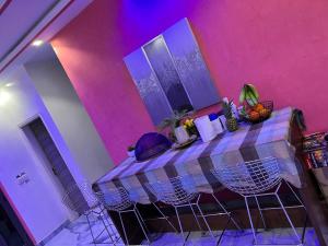 a table in a room with a pink wall at Residence Meuble Zac Mbao in Kammba