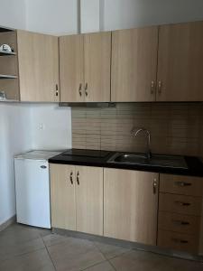 a kitchen with wooden cabinets and a sink at Meta apartment in Ksamil