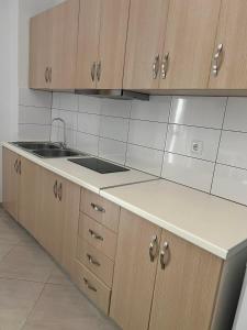 a kitchen with wooden cabinets and a sink at Meta apartment in Ksamil
