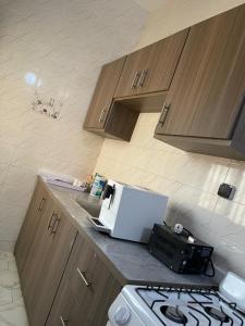 a kitchen with a stove and a microwave on a counter at Residence Meuble Zac Mbao in Kammba +10 photos