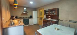 a kitchen with a counter and a table with chairs at La Casa de la Huerta in Vinuesa