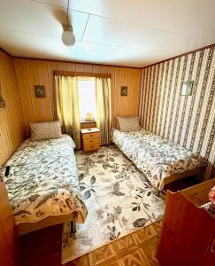 a bedroom with two beds and a window at Fjord Haven in Gryllefjord