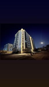 a large white building is lit up at night at Modern Luxury Apartment Central Samarkand in Samarkand