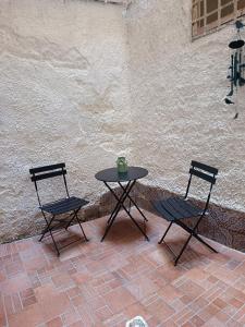 a table and two chairs sitting next to a wall at Casetta d'Ossuna in Palermo