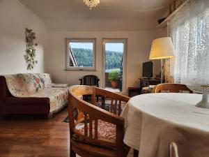 a living room with a table and a couch at Schwarzwald-Ferienwohnungen Begert in Baiersbronn