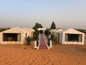 a row of tents in the middle of a desert at Elite Sahara Desert Camp in Merzouga