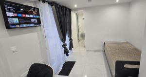 a room with a tv on the wall and a couch at Chez Bio in Coulommiers
