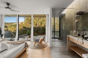 a bedroom with a bed and a large window at Hotel Cuatro Cuatros in Ensenada