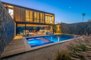 a house with a swimming pool in front of it at Hotel Cuatro Cuatros in Ensenada