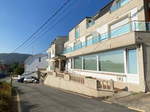 a building with a car parked in front of it at Hotel Riveiro in Sanxenxo