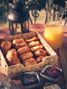 a basket of pastries on a table with orange juice at Mas de la Croix - Chambres d'hôtes in Sernhac +21 photos