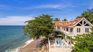 a house on the beach next to the ocean at Tres Sirenas Beach Inn in Rincon