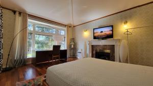 a bedroom with a bed and a fireplace with a tv on the wall at 7Bedroom Beautiful and spacious home in Surrey