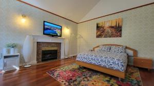 a bedroom with a bed and a fireplace with a television at 7Bedroom Beautiful and spacious home in Surrey