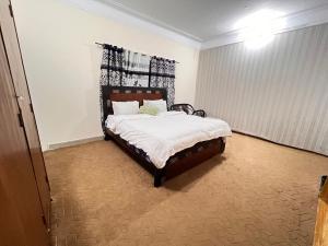 a bedroom with a bed with a black headboard at Diwan longues in Murree