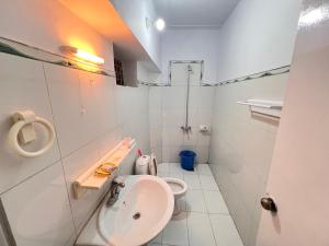 a white bathroom with a sink and a toilet at Diwan longues in Murree