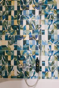 a bathroom with a shower with blue and white tiles at Gartner Hotel in Budapest +34 photos
