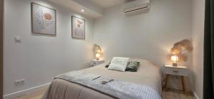 a bedroom with a bed and two lights on two tables at Casa Loulou in Saint-Laurent-dʼAigouze