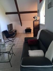 a living room with a couch and a desk at Appart cosy Disney paris in Chalifert
