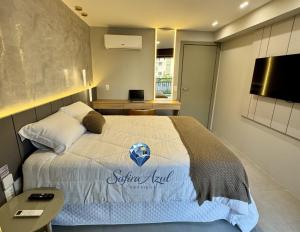 a bedroom with a bed with a sutton hotel sign on it at Safira Azul Luxury Flat Carneiros in Tamandaré