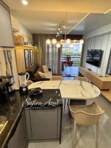 a kitchen and living room with a table and a living room at Safira Azul Luxury Flat Carneiros in Tamandaré