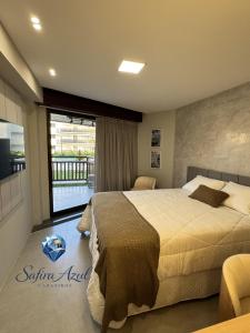 a bedroom with a large bed and a balcony at Safira Azul Luxury Flat Carneiros in Tamandaré