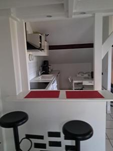 a small kitchen with two stools and a counter at Appart cosy Disney paris in Chalifert +1 photo