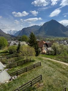 a farm with a fence and mountains in the background at Apartment Planika Bovec in Bovec