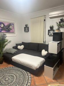 a living room with a couch and a bed at Swallows Nest in Quarteira +25 photos