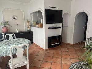 a living room with a table and a flat screen tv at Swallows Nest in Quarteira