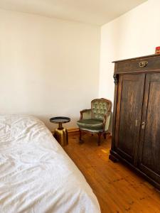 a bedroom with a bed and a chair and a dresser at NAO Eifelhaus von 1875 mit Garten in Üxheim +35 photos