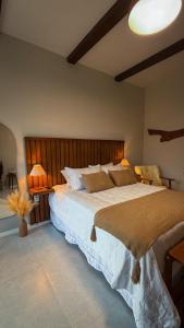 a bedroom with a large bed with two lamps at Villa di Trevi Hospedagem em Pedra Azul in Domingos Martins
