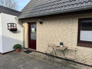 a table and chairs in front of a house at Weesby Süderstraße 3.3 in Weesby