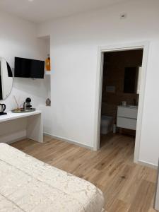 a white room with a bed and a bathroom at Marra Home B&B in Barletta