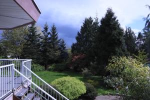 a view from the porch of a house with trees at 7Bedroom Beautiful and spacious home in Surrey