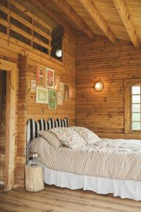 a bedroom with a bed in a wooden room at Le Chalet du Michel in Hardifort