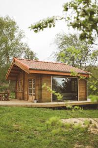 a small house with a large window in a yard at Le Chalet du Michel in Hardifort