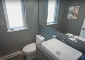 a bathroom with a white toilet and a sink at Elite Townhouse at the Shipyaards in North Vancouver