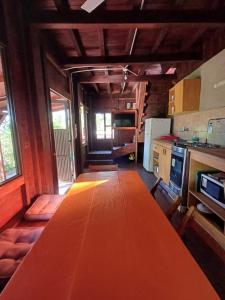 a kitchen with a long wooden table in a room at Bambú Cabaña in El Soberbio