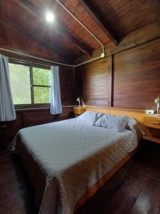 a bedroom with a bed in a wooden room at Bambú Cabaña in El Soberbio