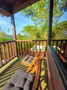 a porch with a hammock and chairs on it at Bambú Cabaña in El Soberbio