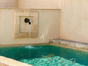 a swimming pool with a water fountain at Maison Douce in Châteaurenard