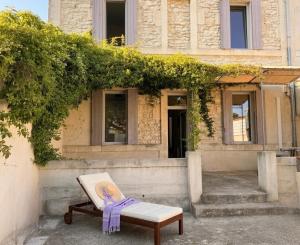 a bench with a purple ribbon sitting in front of a building at Maison Douce in Châteaurenard