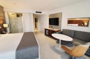 a hotel room with a bed and a table and a couch at Suíte Luxo Mar em Hotel Nacional in Rio de Janeiro +2 photos