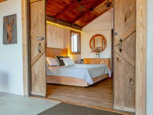 a bedroom with a bed and a large wooden door at Premium Lakefront Cabin 1 The Armadillo in Bastrop +28 photos