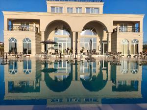 a building with a pool of water in front of it at Orion Palace Boutique Hotel in Durrës
