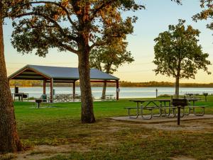 a picnic shelter in a park next to a lake at Premium Lakefront Cabin 1 The Armadillo in Bastrop