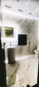 a marble bathroom with a sink and a toilet at Dawood Apartments Bahria Town Lahore in Lahore